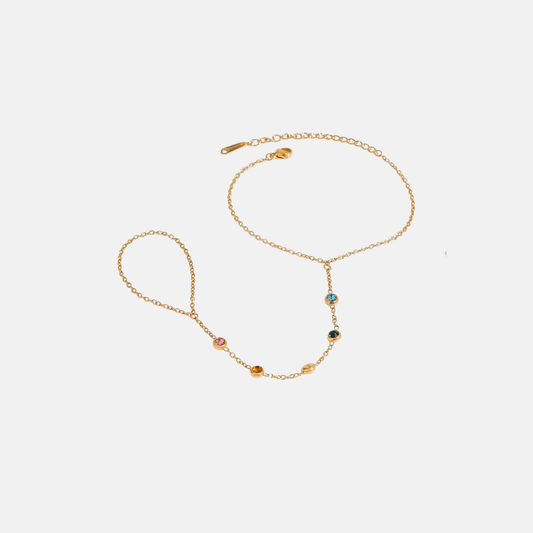 A delicate gold handchain with small colorful gemstone beads, displayed on a light gray background.